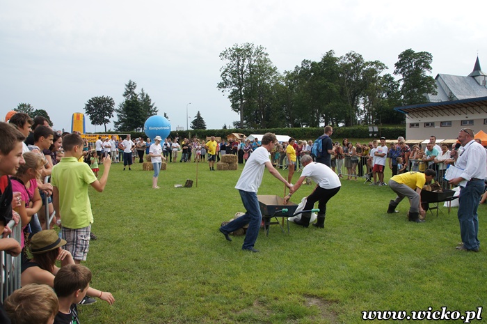 Fotografia z Dni Gminy Wicko 2012 przedstawiająca ”Wielką Rywalizację Otwartego Turnieju Administracji” - konkurencja sztafeta wiejska w gumiakach. 